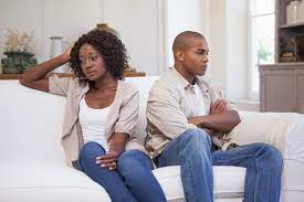 a separating couple sitting facing away from one another on the couch